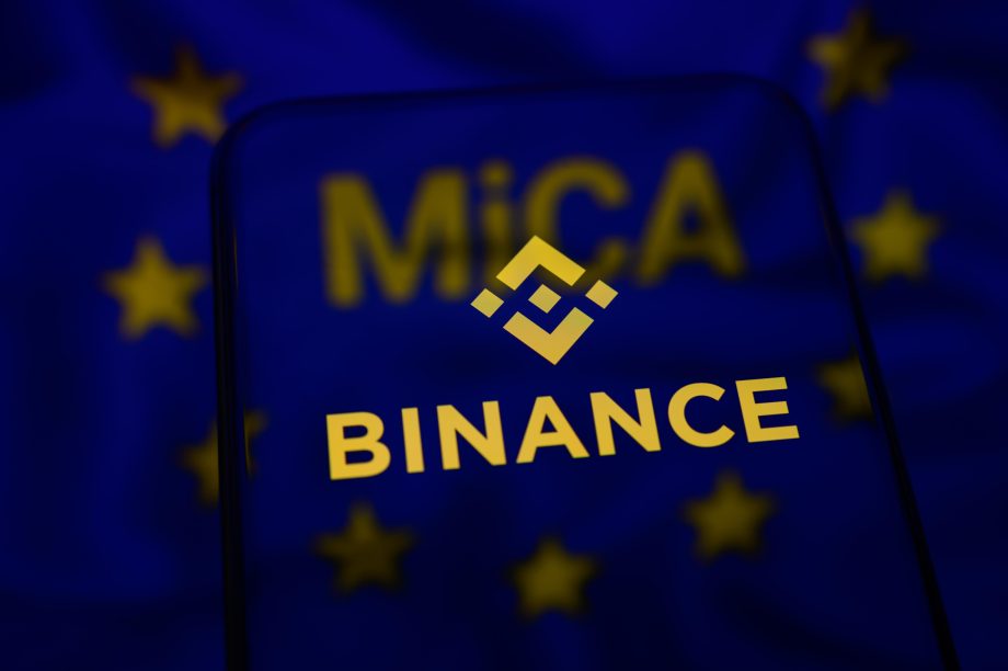 Das Binance-Logo vor einer verschwommenen EU-Flagge.