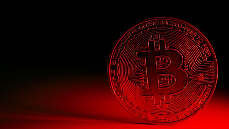 Bitcoin-Münze vor bedrohlichem Hintergrund