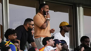 Drake im Stadion verfolgt ein Fußballspiel.