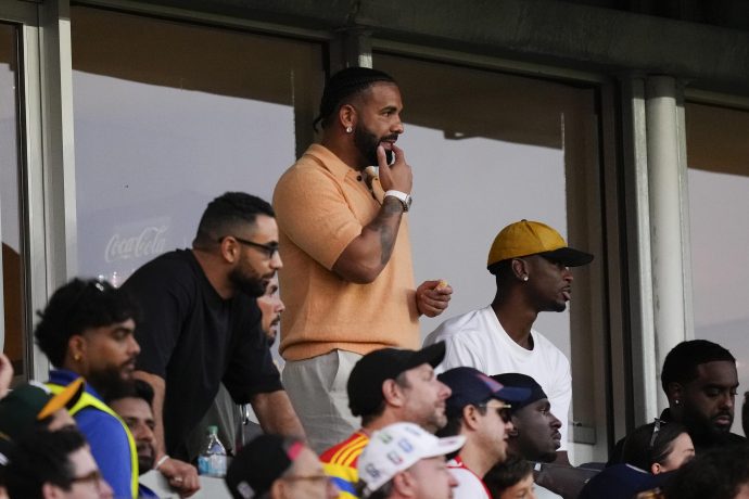 Drake im Stadion verfolgt ein Fußballspiel.