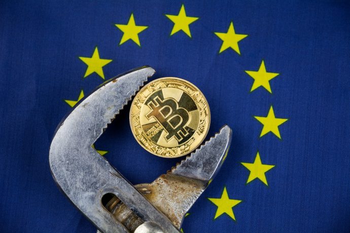 Eine Bitcoin-Münze vor einer Europa-Flagge