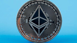 Eine Ethereum-Münze steht vor einem hellblauen Hintergrund