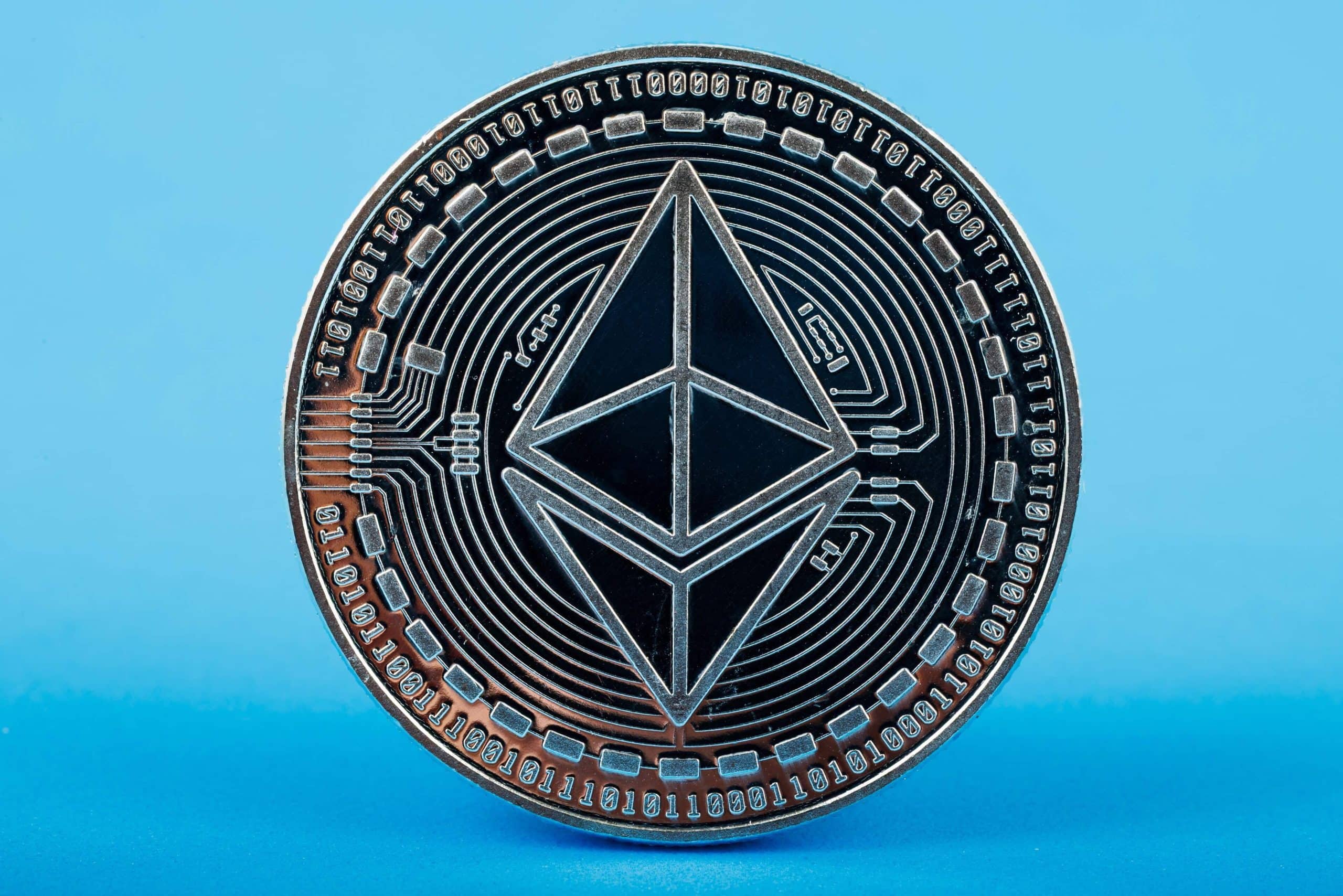 Eine Ethereum-Münze steht vor einem hellblauen Hintergrund