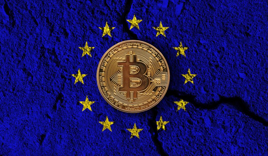 Eine goldene Bitcoin-Münze umreundet von den Sternen der EU auf blauem Hintergrund, der brüchig ist.