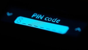 Das Bild zeigt eine Nahaufnahme des Displays einer Hardware Wallet oder eines ähnlichen Krypto-Geräts. Im Fokus steht die Anzeige mit der Aufschrift „PIN code“, darunter ist ein Eingabefeld für die PIN zu erkennen.