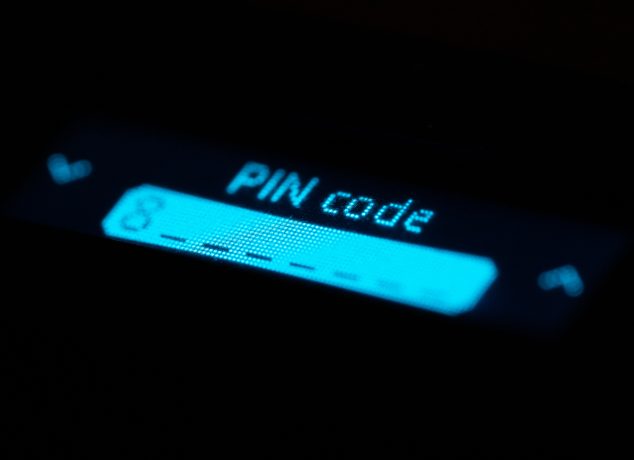 Das Bild zeigt eine Nahaufnahme des Displays einer Hardware Wallet oder eines ähnlichen Krypto-Geräts. Im Fokus steht die Anzeige mit der Aufschrift „PIN code“, darunter ist ein Eingabefeld für die PIN zu erkennen.
