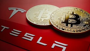 Das Bild zeigt das Tesla-Logo und Bitcoin-Münzen