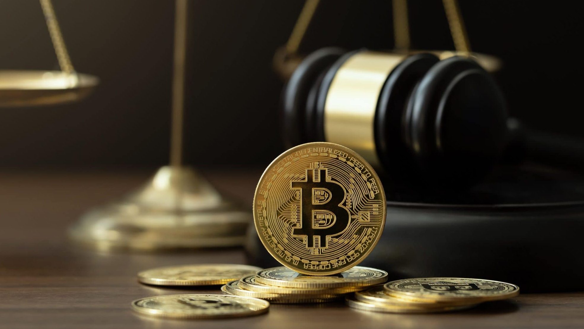Das Bild zeigt eine Bitcoin-Münze vor einem Gerichtshammer