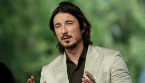 Der Robinhood CEO Vlad Tenev gestikuliert in einem beigen Anzug