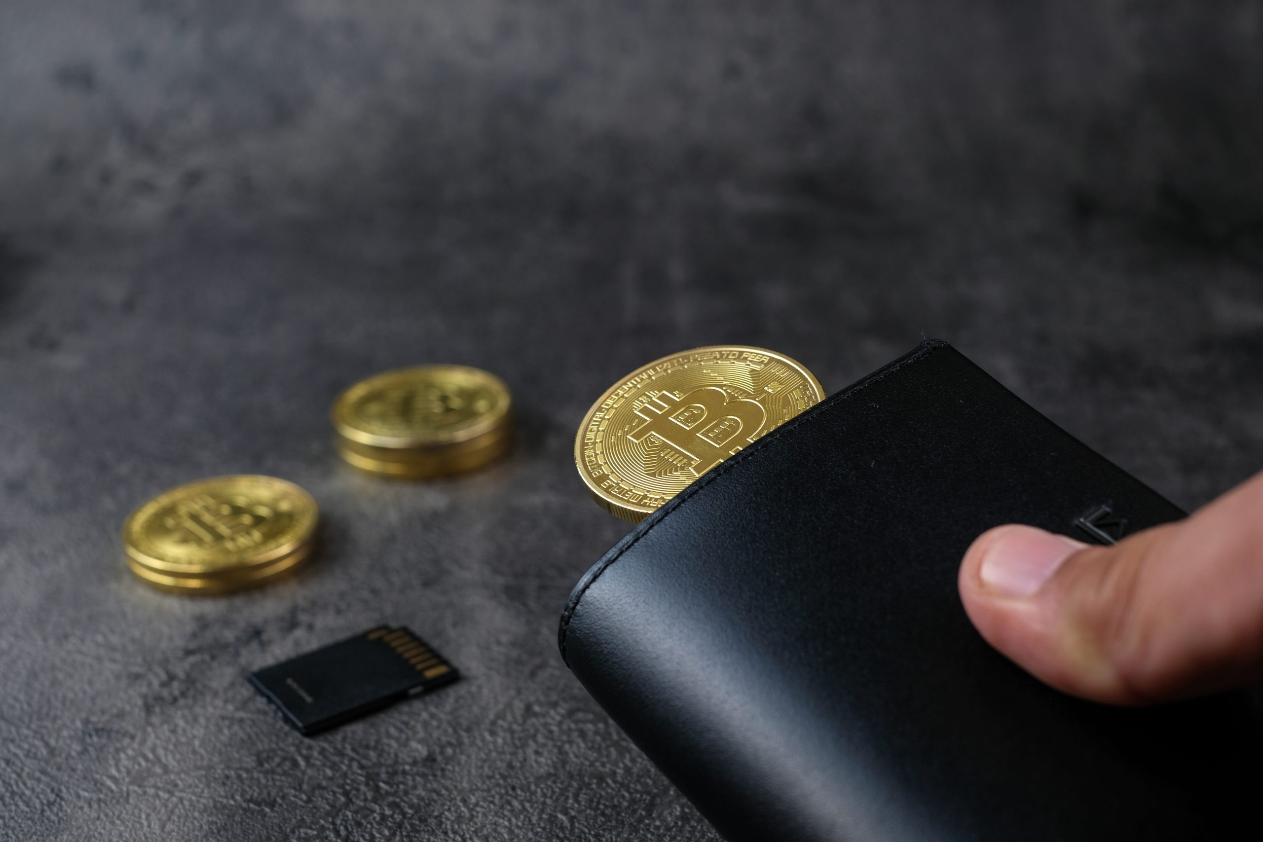 Das Bild zeigt eine Brieftasche und Bitcoin-Münzen