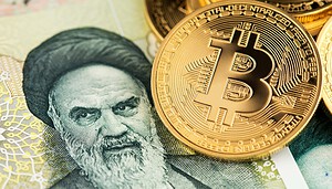 Bitcoin-Münzen liegen auf einem iranischen Geldschein