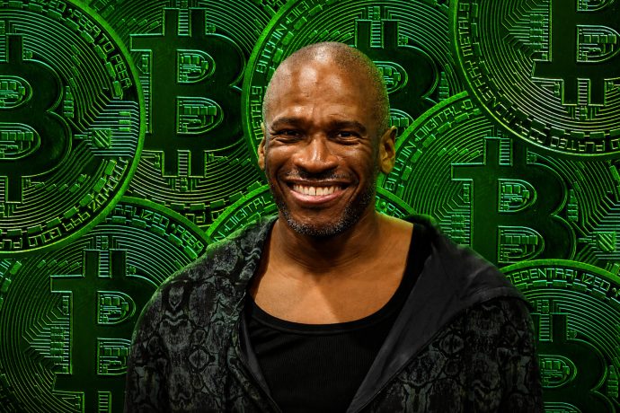Arthur Hayes vor einem Hintergrund aus grünen Bitcoin-Münzen.