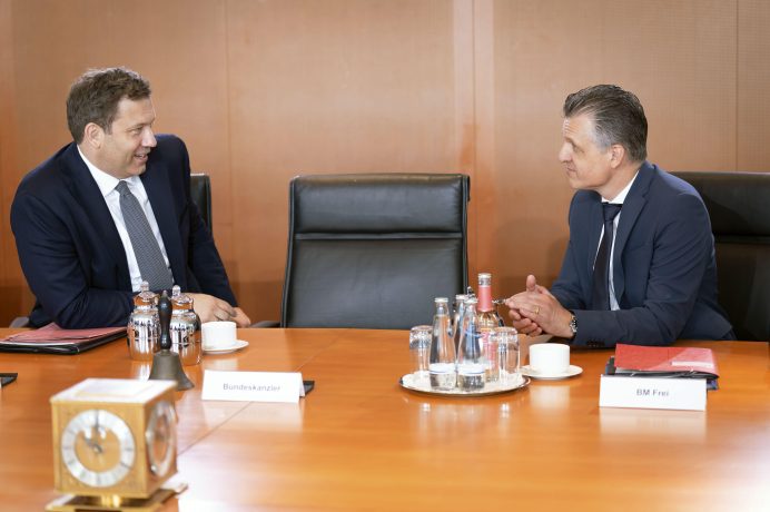 Lars Klingbeil und Thorsten Frei unterhalten sich an einem Konferenztisch.