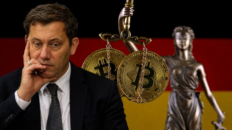 Bundesfinanzminister Lars Klingbeil sitzt im Vordergrund mit nachdenklich auf die Hand gestütztem Gesicht. Hinter ihm hängen zwei goldene Bitcoin-Münzen an einer Waage; rechts steht eine unscharfe Justitia vor den Farben der deutschen Flagge.