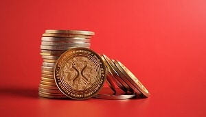 Das Bild zeigt XRP-Münzen auf rotem Hintergrund.