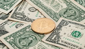 Das Bild zeigt eine Bitcoin-Münze auf US-Dollar-Scheinen