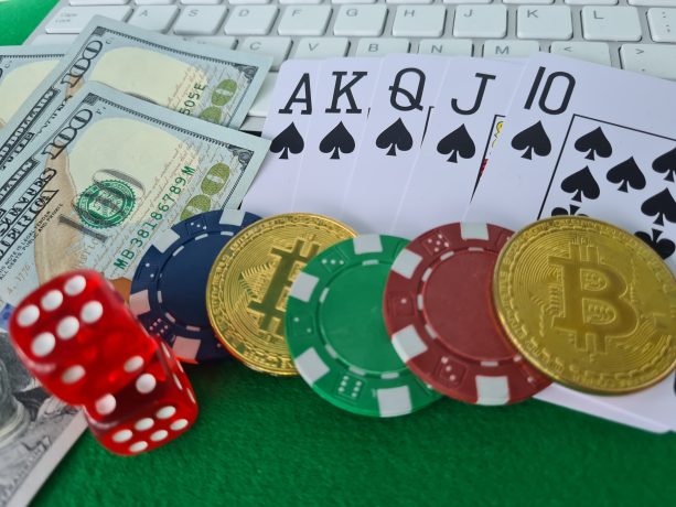 Das Bild zeigt Bitcoin-Münzen neben Spielkarten und Würfeln
