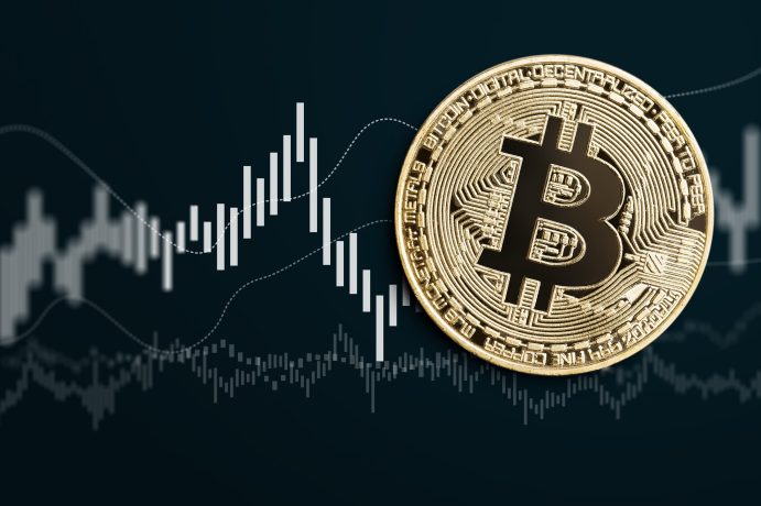 Eine Bitcoin-Münze vor einem weißen Kurschart auf schwarzem Hintergrund