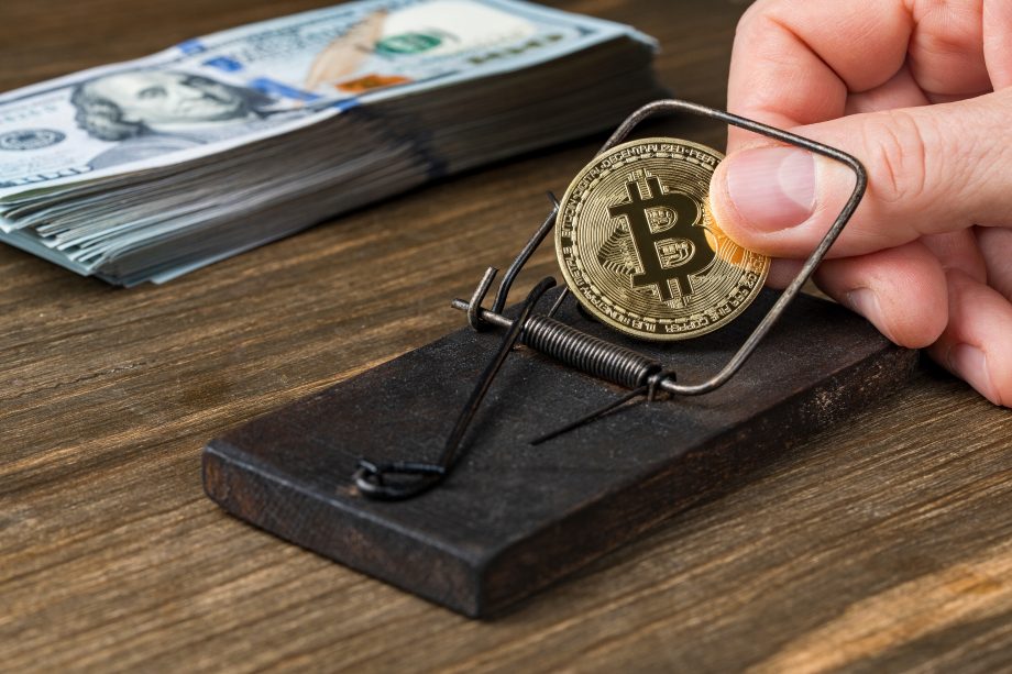 Das Bild zeigt eine Bitcoin-Münze in einer Mausefalle