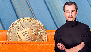 Man sieht eine Bitcoin-Münze aus einer orangen Geldbörse hinausragen. Daneben steht ein Mann mit schwarzem Rollkragenpullover.