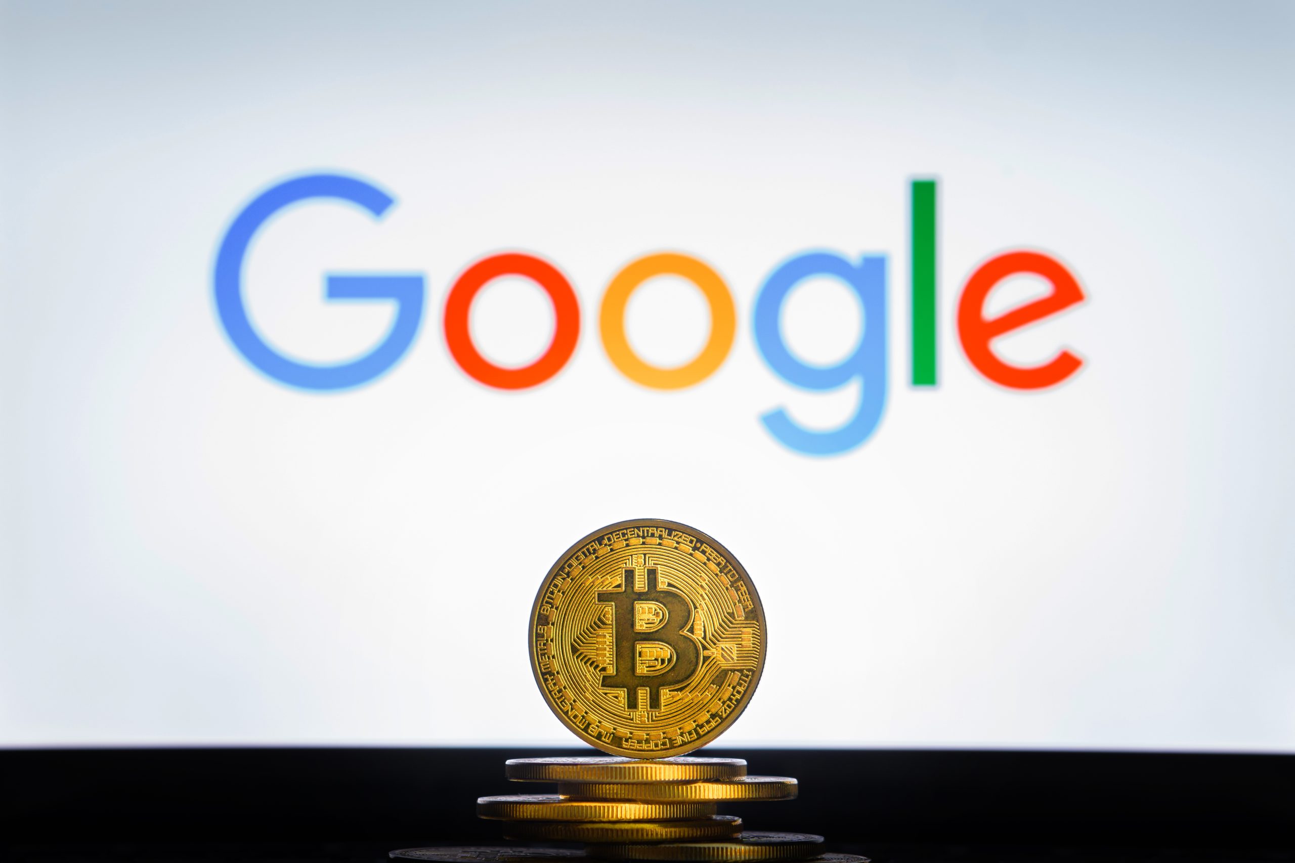 Das Bild zeigt eine Bitcoin-Münze und das Google-Logo