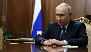 Putin sitzt an einem Tisch