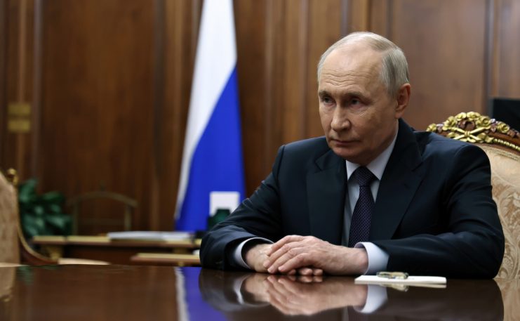 Putin sitzt an einem Tisch