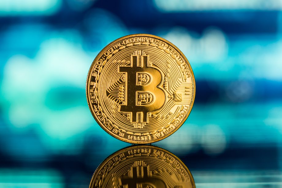 Eine Bitcoin-Münze vor blauem Hintergrund
