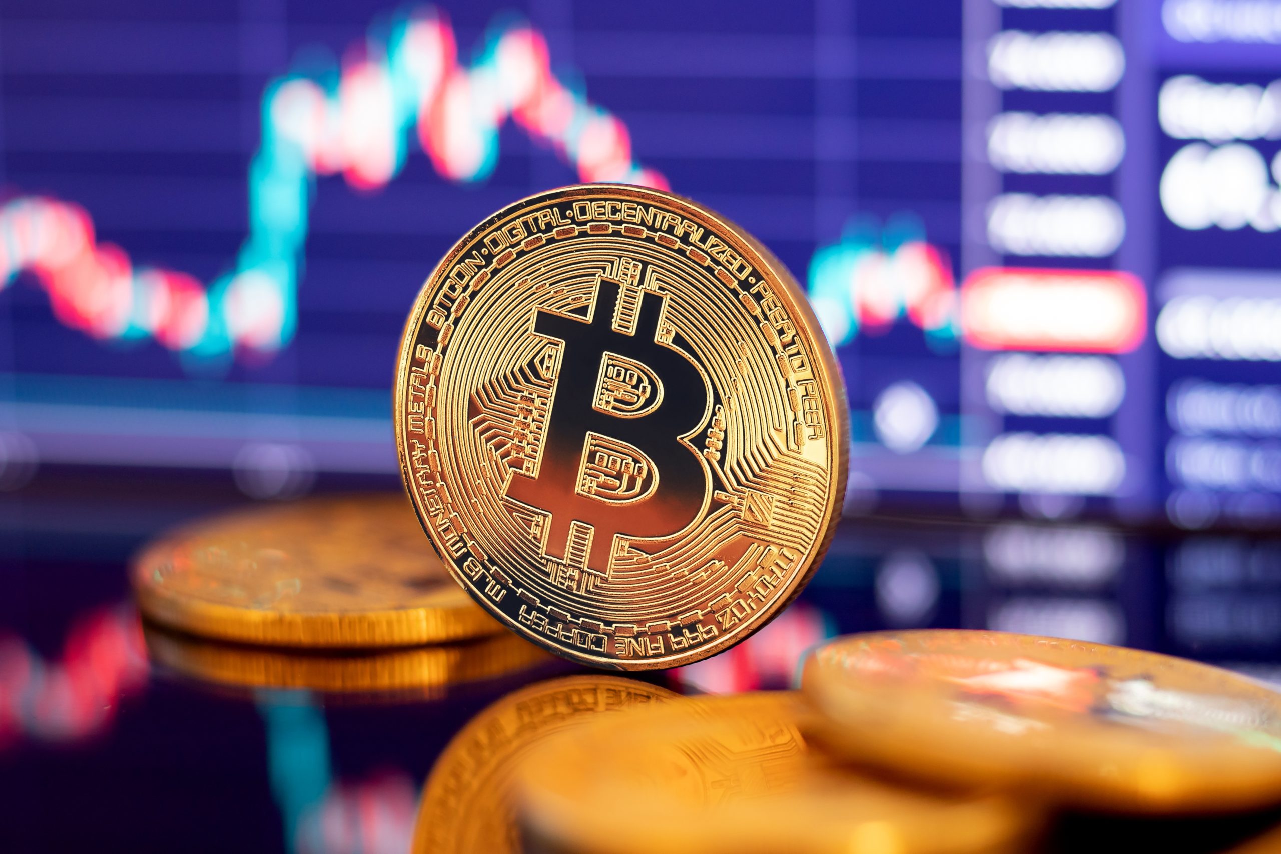 Eine Bitcoin-Münze vor einem Chart