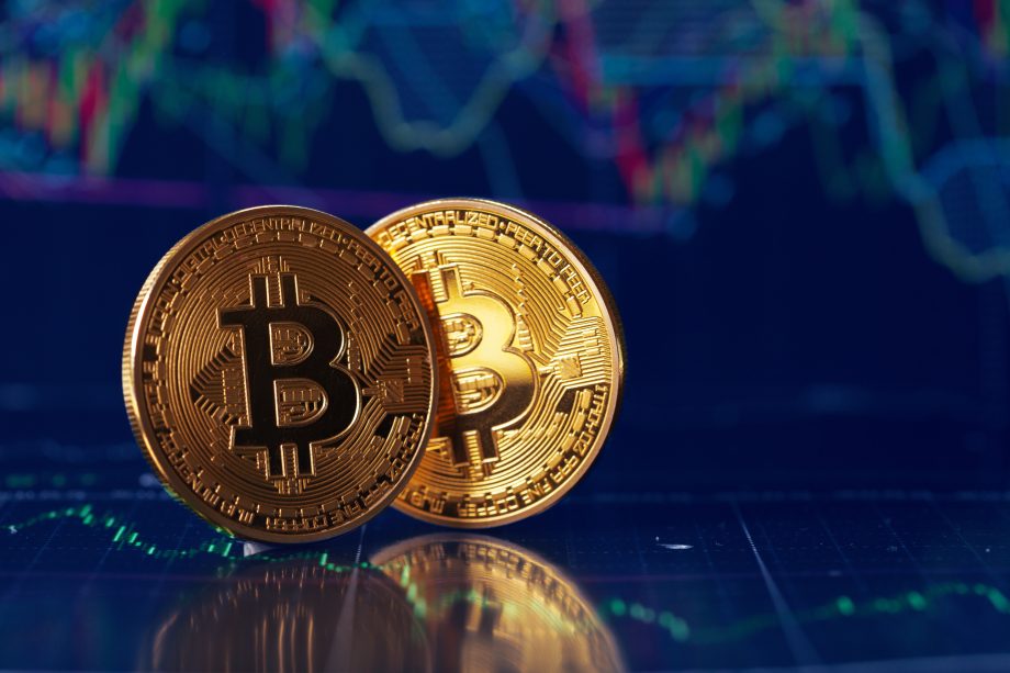 Zwei Bitcoin-Münzen vor einem Chart