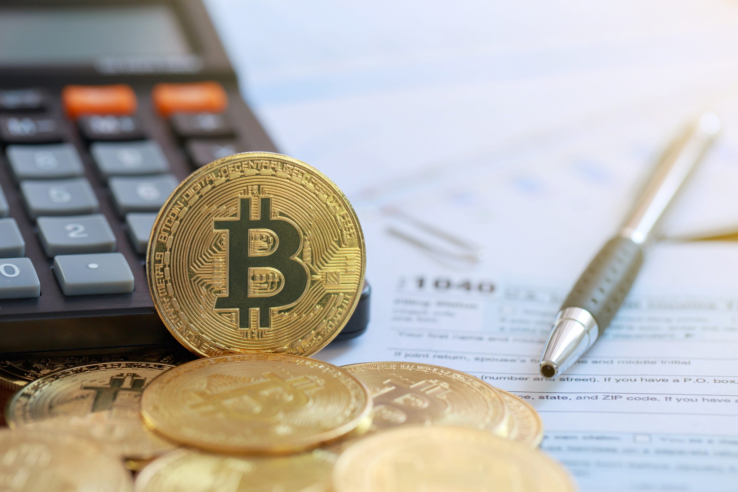Eine Bitcoin-Münze vor einem Taschenrechner