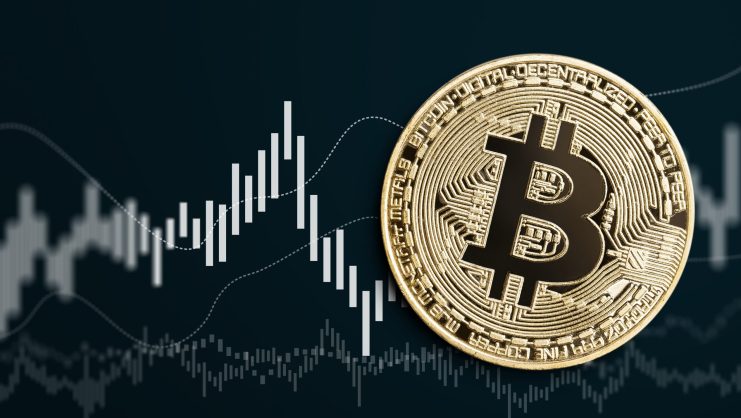 Bitcoin-Münze vor schwarzem Chartbild