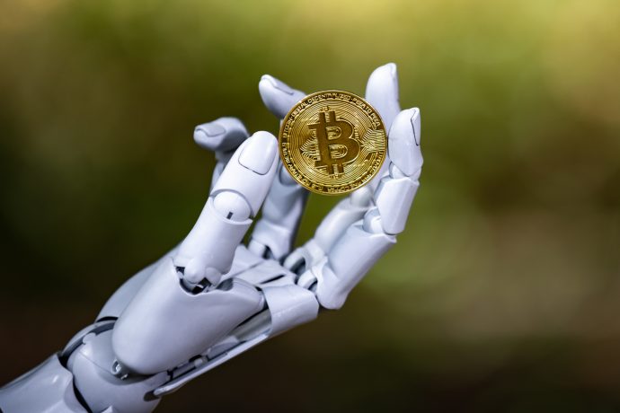 Eine Roboterhand hält einen Bitcoin