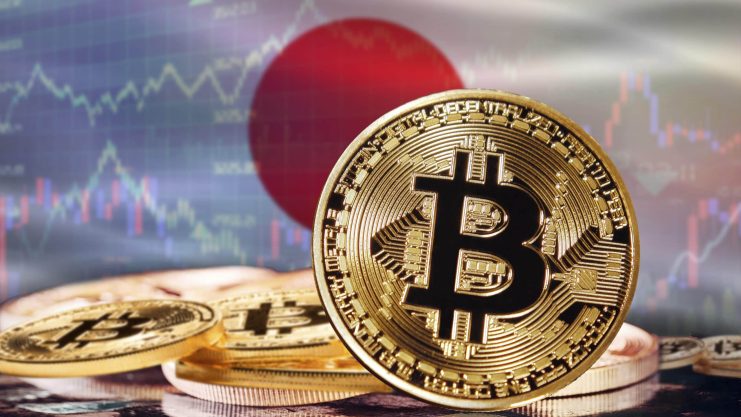 Nach dem Zinsentscheid konnten Bitcoin und Co. zulegen Das Bild zeigt eine Bitcoin-Münze vor der japanischen Flagge