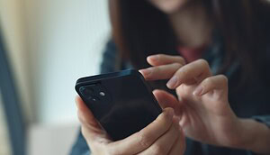 Eine Person bedient ein Smartphone. Die Aufnahme steht sinnbildlich für die digitale Verwahrung und Verwaltung von Kryptowährungen.
