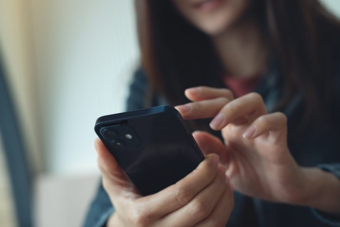 Eine Person bedient ein Smartphone. Die Aufnahme steht sinnbildlich für die digitale Verwahrung und Verwaltung von Kryptowährungen.
