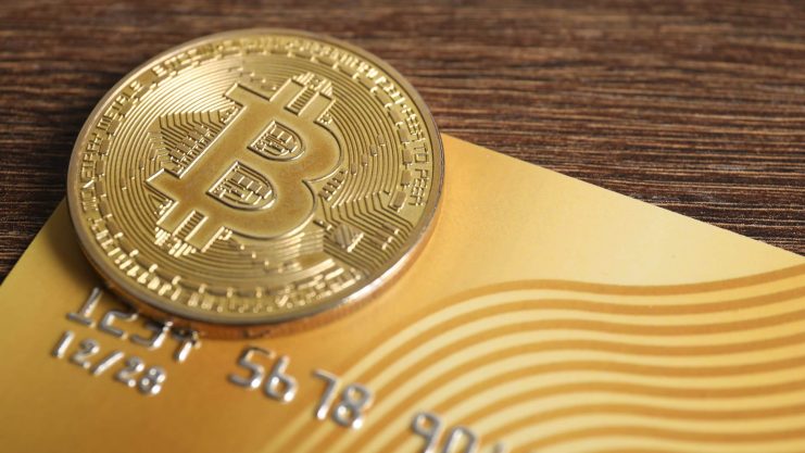 Das Bild zeigt eine Bitcoin-Münze und eine Kreditkarte