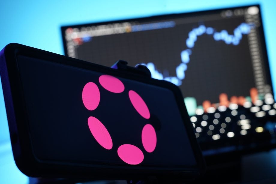 Polkadot-Logo auf einem Smartphone vor einem Chart