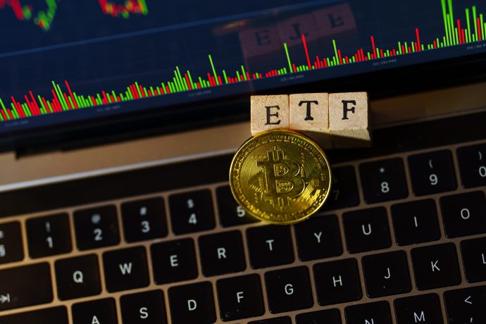 Das Bild zeigt eine Bitcoin-Münze mit dem Wort ETF auf einer Tastatur