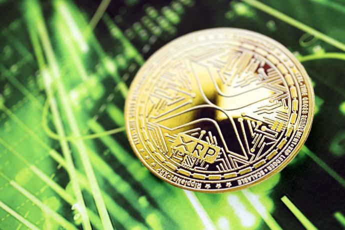 Ripple-Münze vor grünem Kurs-Chart.