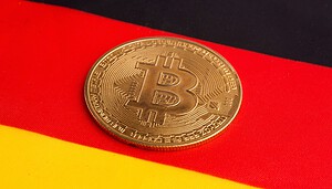 Eine Bitcoin-Münze vor einer Deutschlandflagge