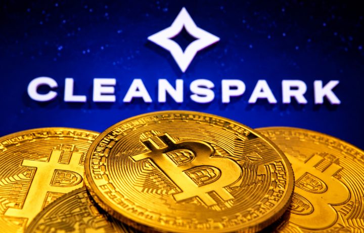 CleanSpark Logo mit weißem Stern-Symbol und Schriftzug vor einer dunkelblauen Wand mit Sternenmuster