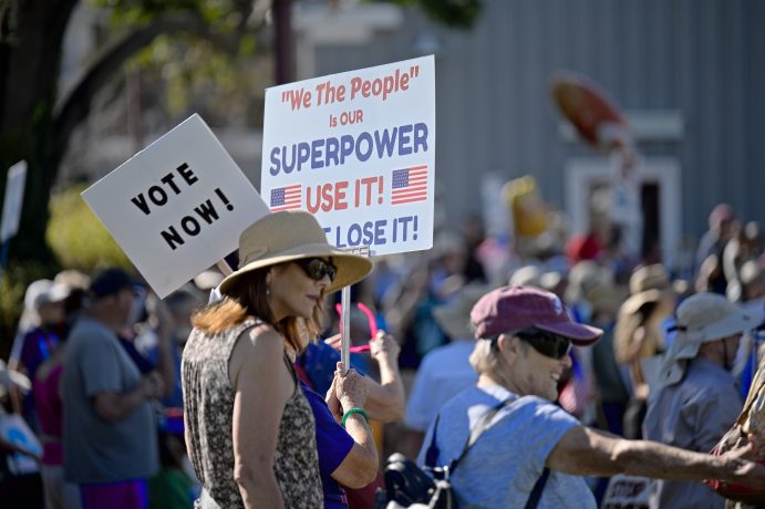Demonstrationen in den USA, Frau mit "Vote Now" Transparent.