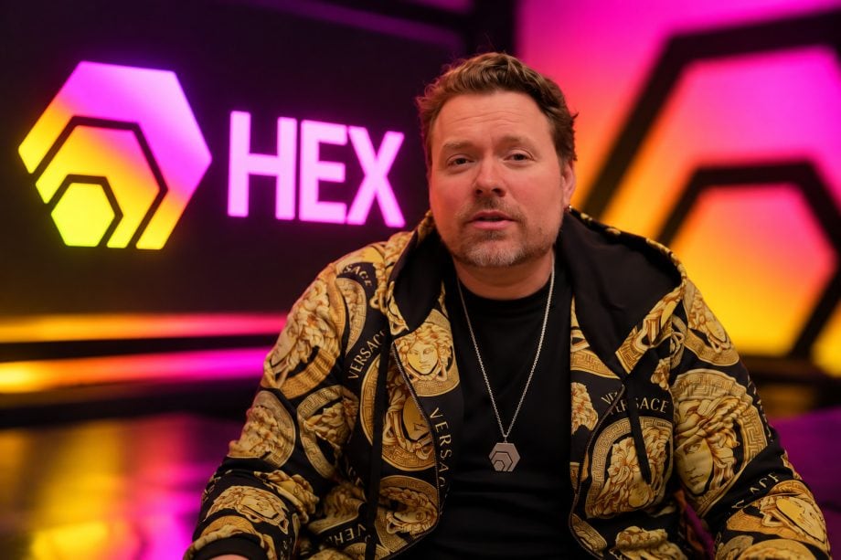Richard Heart, Gründer der Kryptowährung HEX, vor einem pink-orange leuchtenden Hintergrund mit dem HEX-Logo.