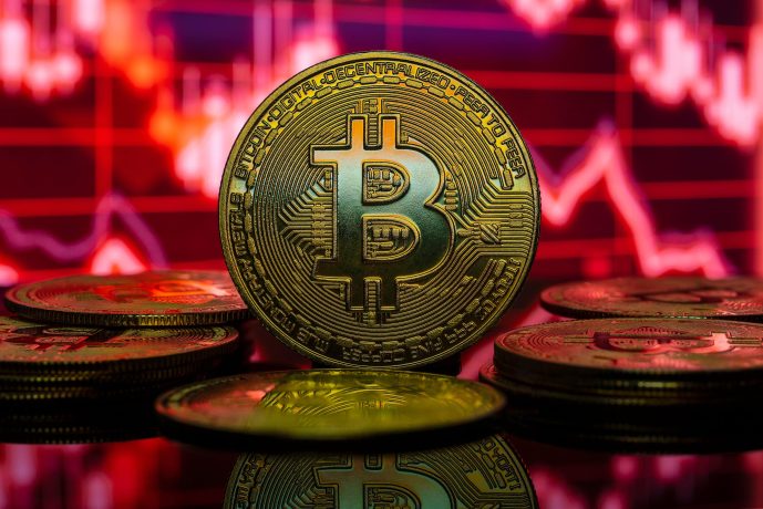Eine Bitcoin-Münze vor rotem Hintergrund