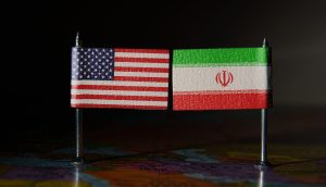 Das Bild zeigt eine amerikanische und iranische Flagge