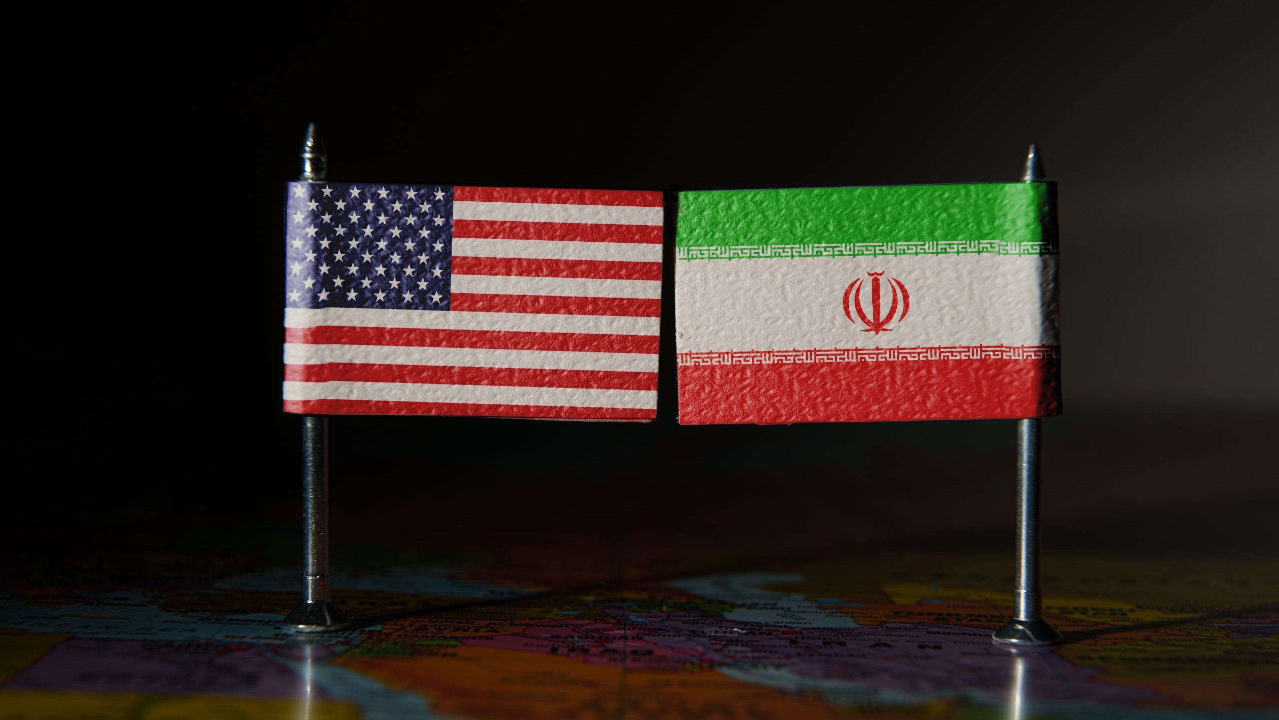 Das Bild zeigt eine amerikanische und iranische Flagge