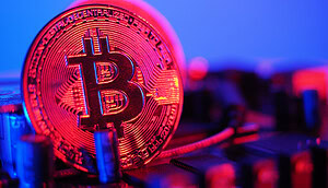 Eine rote Bitcoin-Münze vor blauem Hintergrund