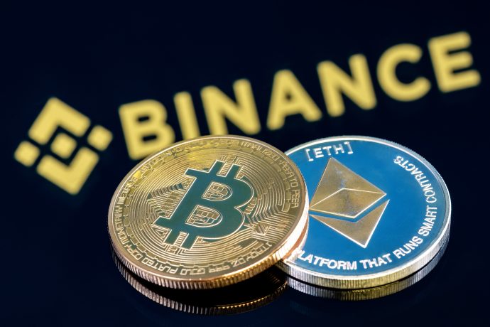 Bitcoin- und Ethereum-Münze liegen vor Binance-Logo