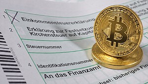 Man sieht ein deutsches Steuerformular und zwei Bitcoin-Münzen.